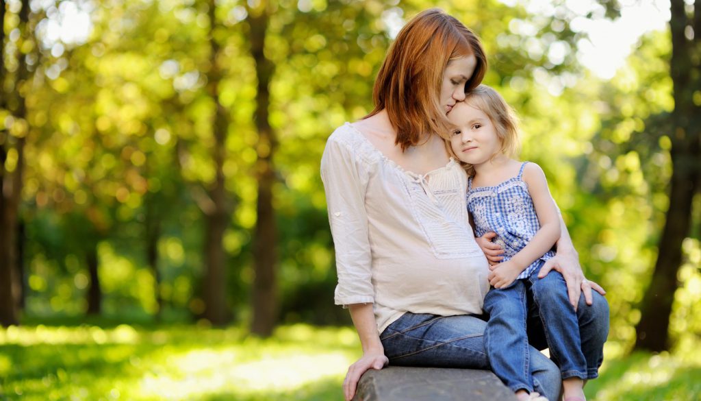 Pregnant mother with her daughter outdoors